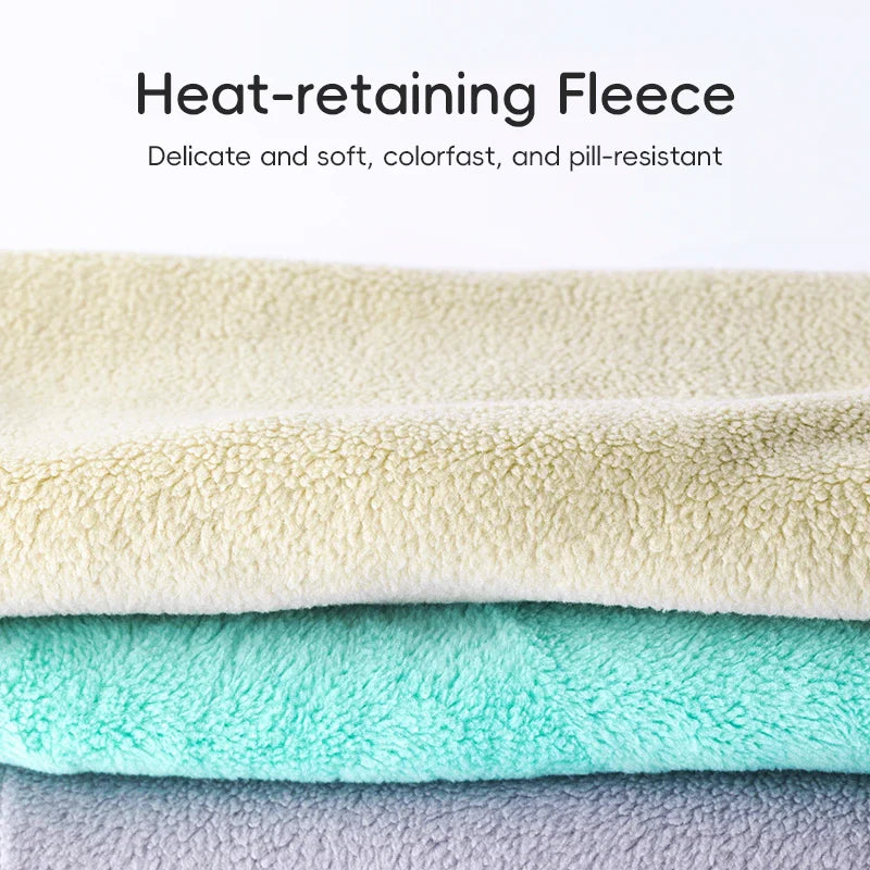 Stack of heat-retaining fleece fabric in beige, green, and blue on a white background.