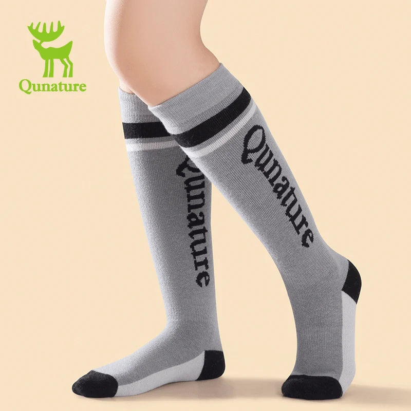 A person wearing a pair of gray wool blend children's ski socks with thick fine terry lining