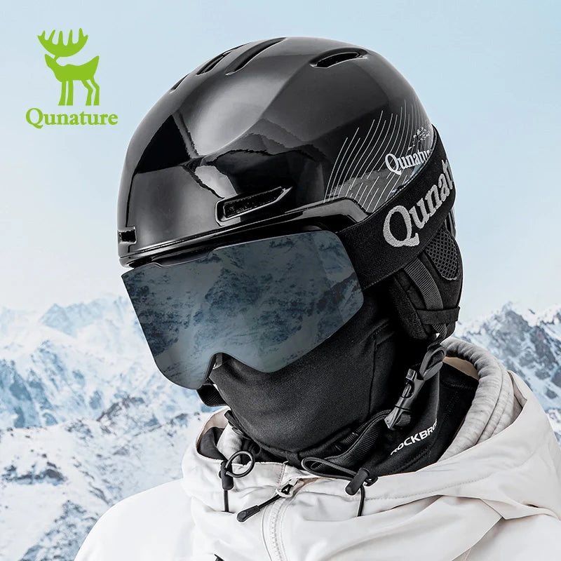 Person wearing a black helmet with goggles and a white jacket in front of a snowy mountain landscape, featuring the Qunature brand.
