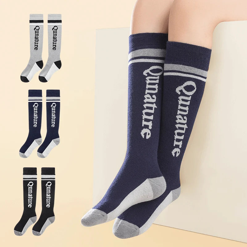 A person wearing a pair of navy wool blend children's ski socks with thick fine terry lining