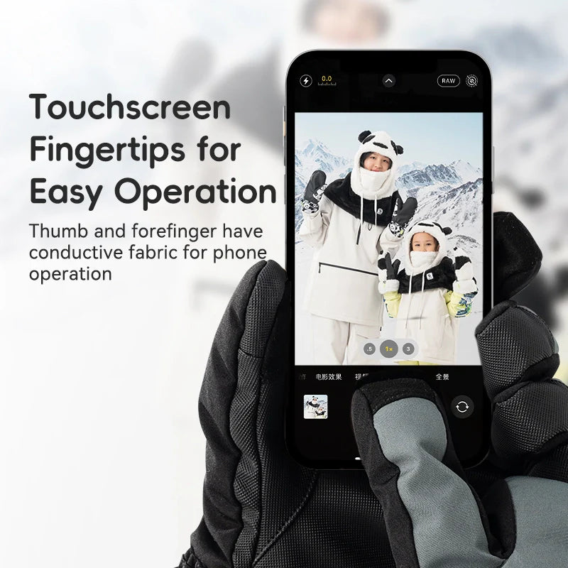 Person wearing gloves holding a phone with a snowy landscape and panda-themed outfit displayed on the screen.